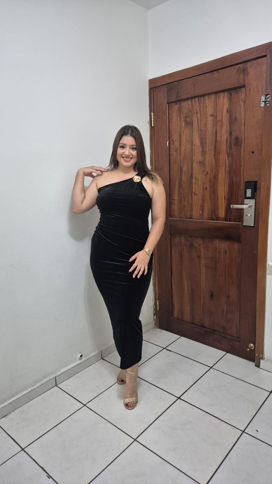 A woman from Honduras in a black dress smiling, the kind of person you meet in OmeTV-style cam chat