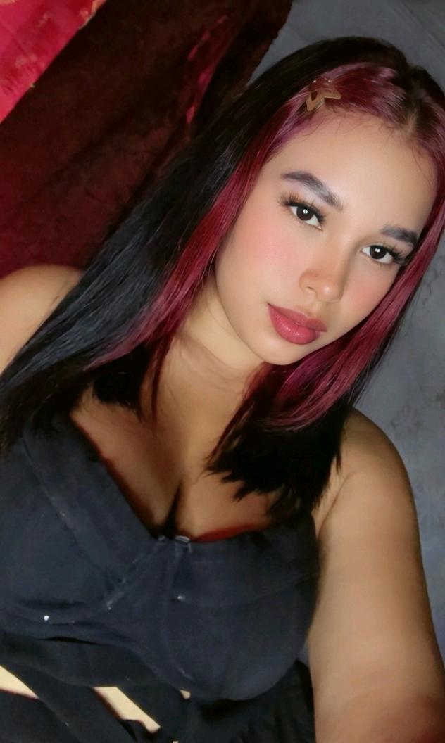 A girl from Honduras with red streaks in her hair, waiting for a video chat with girls who want to talk